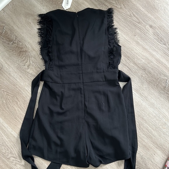 Black pleated front romper with lace trim sleeves and neck line - Picture 7 of 10